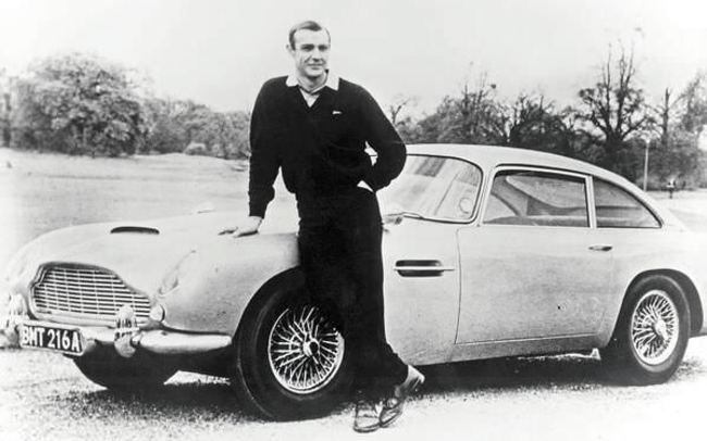 Шон Коннери в роли Джеймса Бонда позирует рядом с Aston Martin DB5, 1965 год