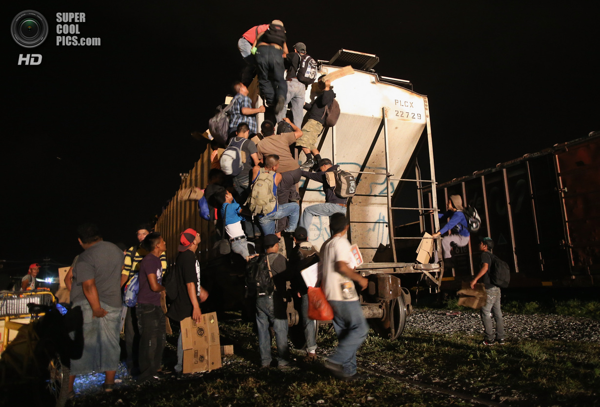 Мексика. Арриага, Чьяпас. 4 августа. Гватемальские нелегальные иммигранты влазят на грузовой поезд, направляющийся на север. (John Moore/Getty Images)