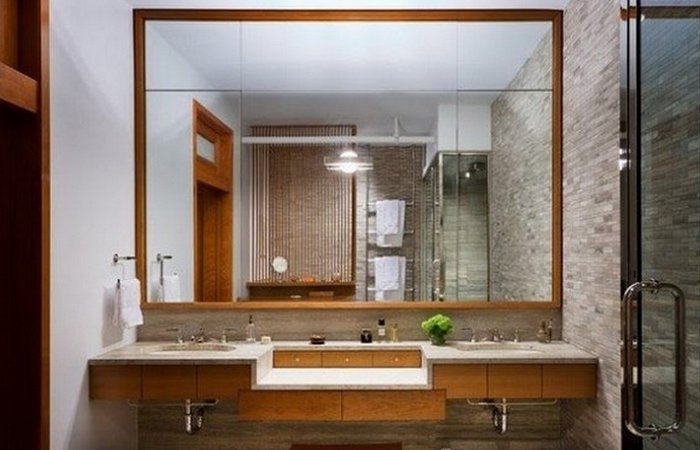 Большое зеркало с обрамлением в ванной комнате.