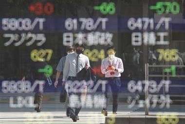 FILE PHOTO: People wearing protective masks, amid the coronavirus disease (COVID-19) outbreak, are reflected on an electronic board displaying Japan's stock prices outside a brokerage in Tokyo, Japan, October 5, 2021. REUTERS/Kim Kyung-Hoon
