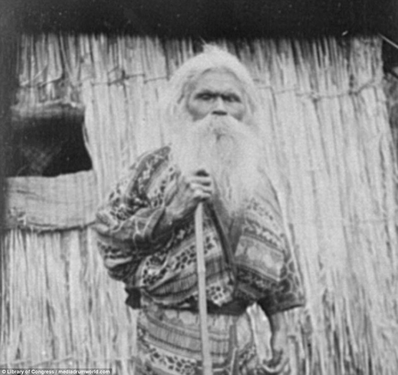 Пожилой айн с палкой у хижины айны, история, народ, фотография