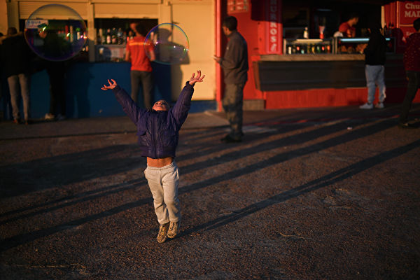 Девочка ловит мыльные пузыри в Монтевидео, Уругвай 