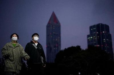 People wearing protective masks walk on a street, following new cases of the coronavirus disease (COVID-19), in Shanghai, China January 4, 2022. REUTERS/Aly Song