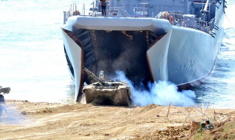 На фото: большой десантный корабль проекта 775 высаживает на побережье танк Т-72Б3 во время одного из эпизодов учений Черноморского флота РФ.