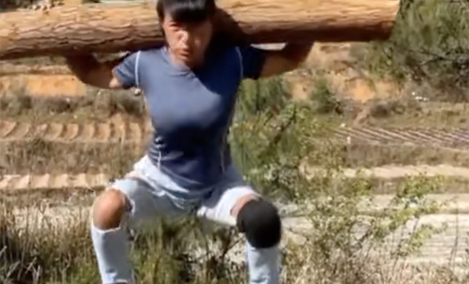 Китаянка повторяет упражнения монахов Шаолинь и тренируется с бревном в руках Культура