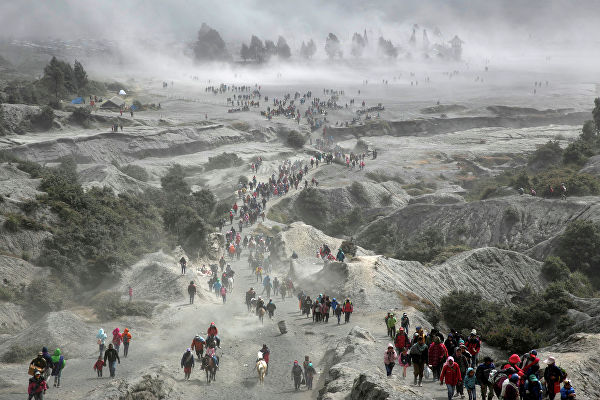 Тенгеры и туристы у вулкана Бромо во время фестиваля Yadnya Kasada в Индонезии