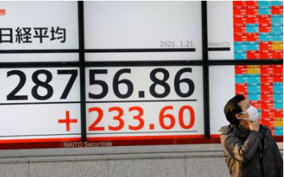 A man wearing a protective mask, amid the coronavirus disease (COVID-19) outbreak, stands in front of an electric board showing Nikkei index outside a brokerage in Tokyo, Japan January 21, 2021. REUTERS/Kim Kyung-Hoon