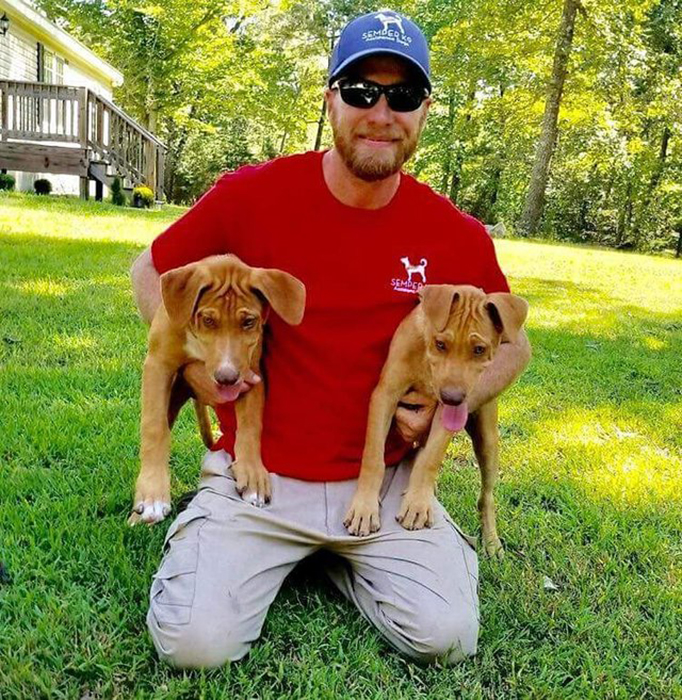 Кристофер Бейт с двумя собаками, обучаемыми в центре.