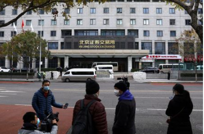 Media reporters stand near the new Beijing Stock Exchange building at the Financial Street, in Beijing, China, November 15, 2021. REUTERS/Tingshu Wang