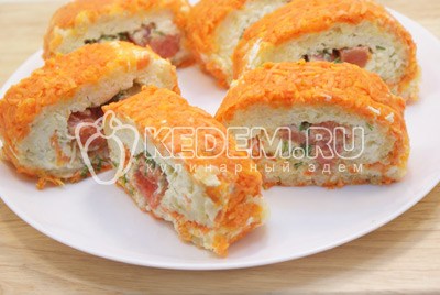 Нарезать порционными кусочками и выложить на плоское блюдо с зеленью