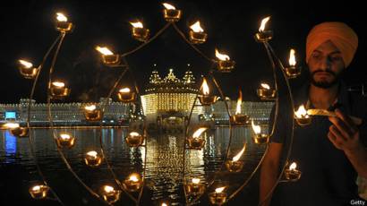 Индийский сикх зажигает свечи во время праздника Банди Чхор Дивас, или Дивали
