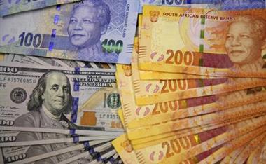 South African bank notes featuring images of former South African President Nelson Mandela (R) are displayed next to the American dollar notes in this photo illustration in Johannesburg, file. REUTERS/Siphiwe Sibeko