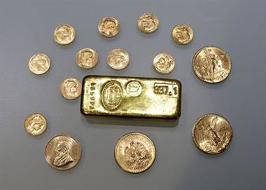 A gold ingot and gold coins are seen in this illustration picture taken November 17, 2017. REUTERS/Eric Gaillard/Illustration/File Photo 
