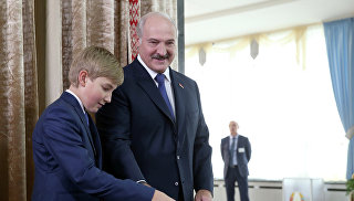 Президент Белоруссии Александр Лукашенко с сыном Николаем на избирательном участке №1 Центрального района Минска