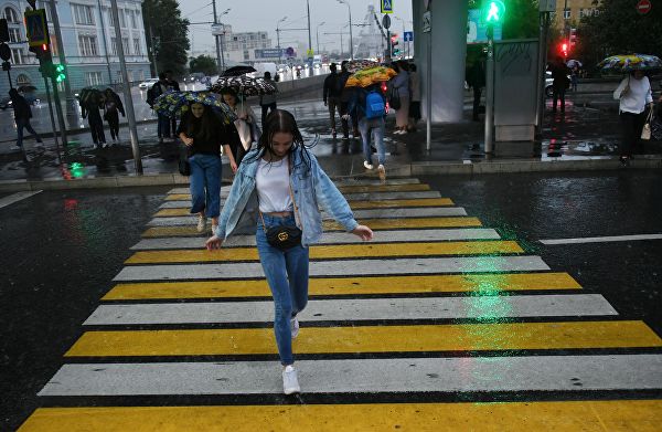 Девушка на пешеходном переходе в Москве во время дождя