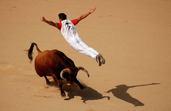 Рекортадор прыгает через быка на фестивале Сан-Фермин в Памплоне, Испания  