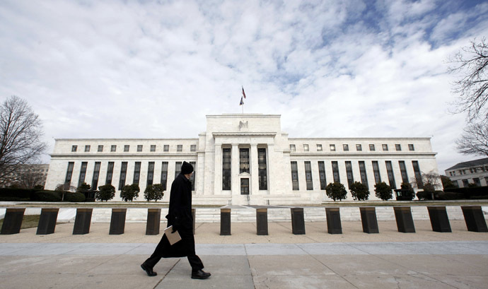 A pedestrian passes the Federal Reserve Building in Washington