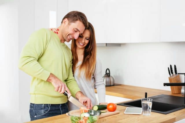 Young pregnant couple cooking together