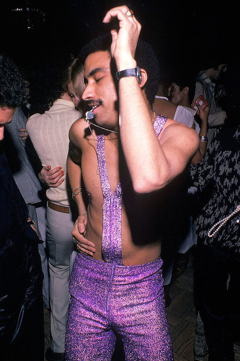 Мужчина в сверкающем фиолетовом наряде дует в свисток на танцполе клуба Studio 54 в Нью-Йорке, 1979 год Веселые, люди, эпоха
