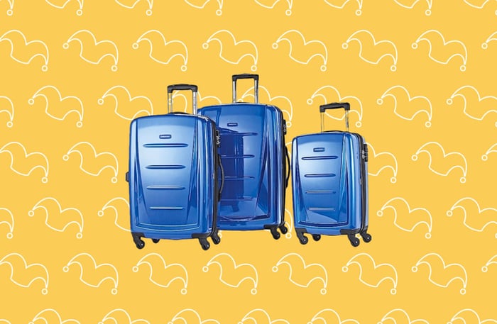 Three blue rolling suitcases against a yellow background