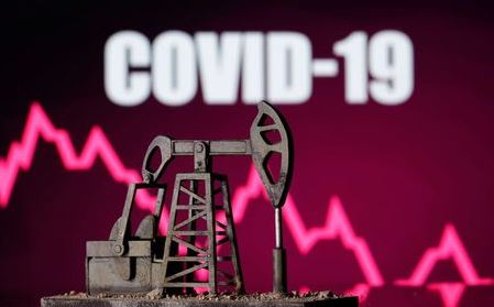 A 3d printed oil pump jack is seen in front of displayed stock graph and 