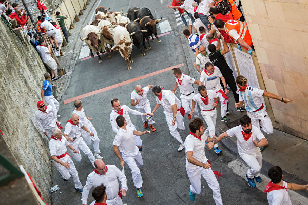 Участники фестиваля Сан-Фермин во время забега с быками в Памплоне