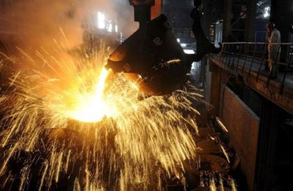 FILE PHOTO: An employee monitors molten iron being poured into a container at a steel plant in Hefei, Anhui province September 9, 2013. REUTERS/Stringer 