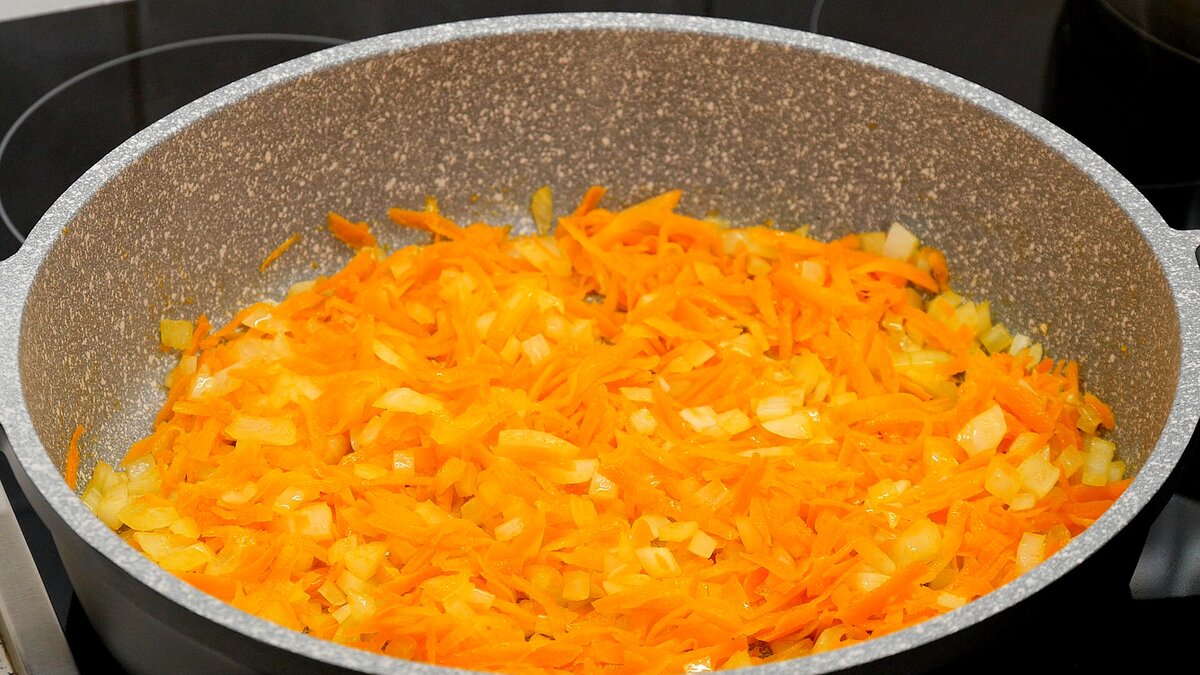 В сковороде разогреваем растительное масло и обжариваем лук с морковью до мягкости, чуть-чуть не до золотистости. Добавляем болгарский перец и продолжаем обжаривать до золотистости лука и моркови.
