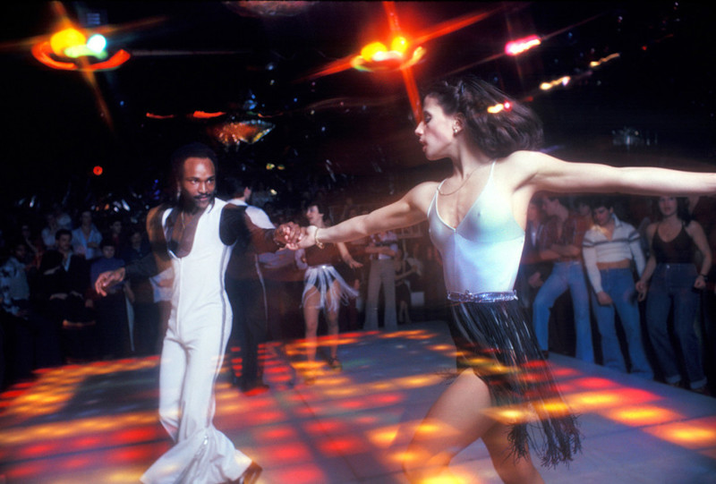 Мужчина и женщина танцуют парный танец посреди танцпола клуба 2001 Odyssey в Бруклине, Нью-Йорк, 1979 год Веселые, люди, эпоха