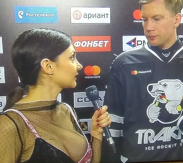 На микрофон смотрит