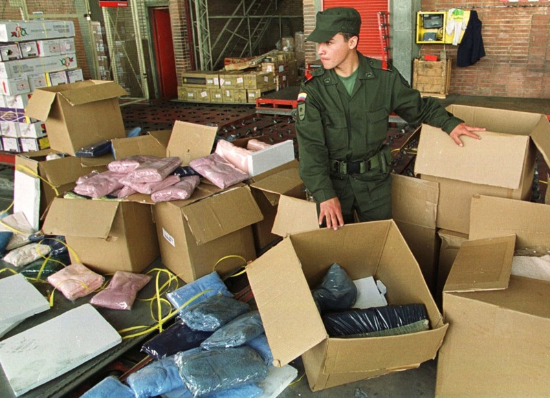 Полицейский пробирается между коробок с кокаином в международном аэропорту Боготы, Колумбия. Полиция обнаружила в них 300 кг кокаина, который должен был быть погружен на рейс авиакомпании Avianca, направляющийся в Мексику. 26 августа 1999 года Пабло Эскобар, в мире, интересное, картель, картель кали, криминал, наркотики