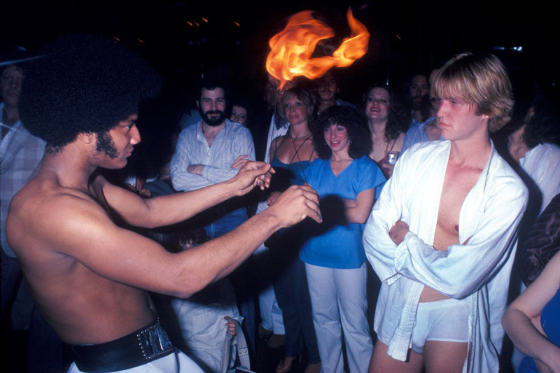 Мужчина выступает с горящими поями в клубе Infinity в Нью-Йорке, 1979 год Веселые, люди, эпоха