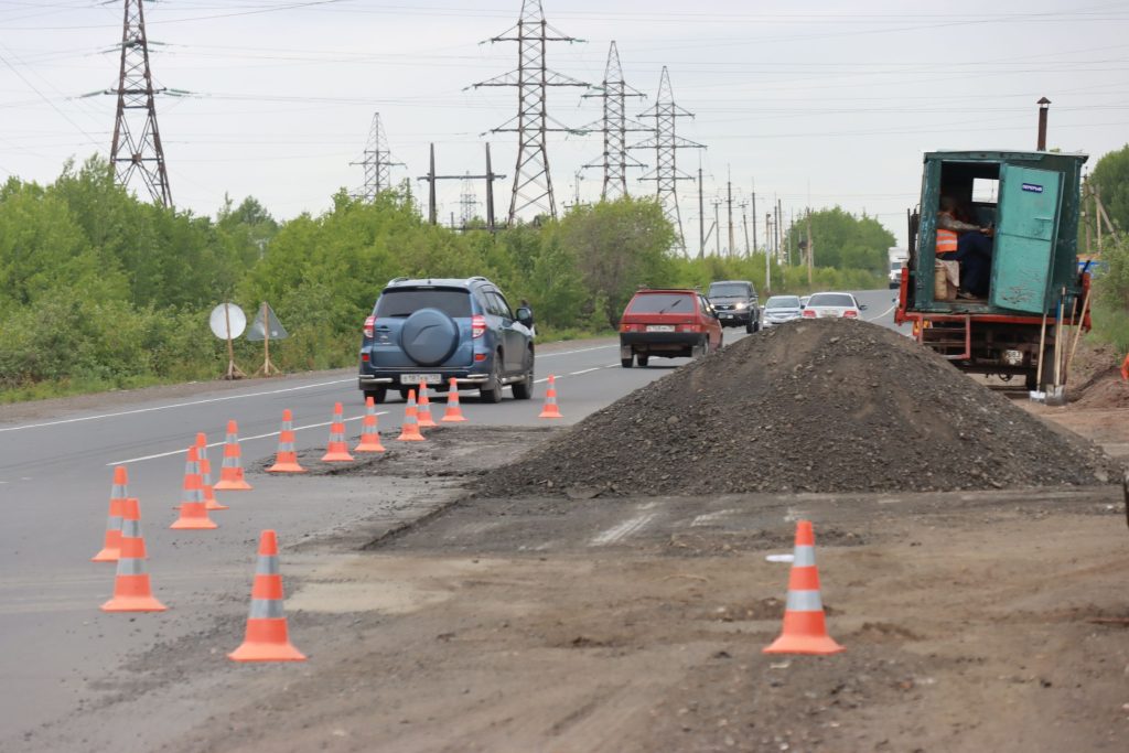 Дорожные работы на трассе, ограждение оранжевыми конусами.