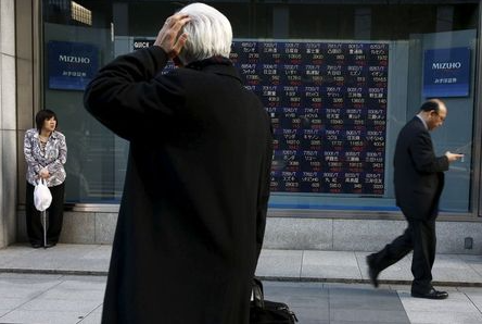 A man looks at an electronic board showing market indices outside a brokerage in Tokyo, Japan, March 2, 2016. Japan's Nikkei surged to a more than three-week high on Wednesday as the dollar rose against the yen after strong U.S. factory and construction data, giving exporters a boost and lifting the overall market. REUTERS/Thomas Peter