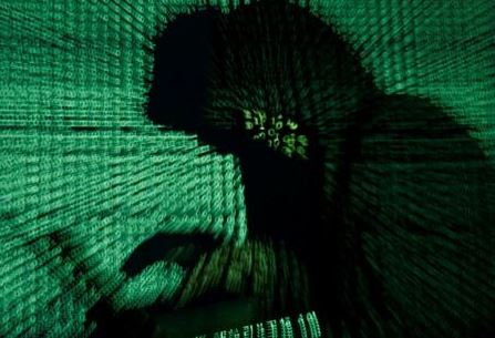 FILE PHOTO: A man holds a laptop computer as cyber code is projected on him in this illustration picture taken on May 13, 2017. REUTERS/Kacper Pempel/Illustration