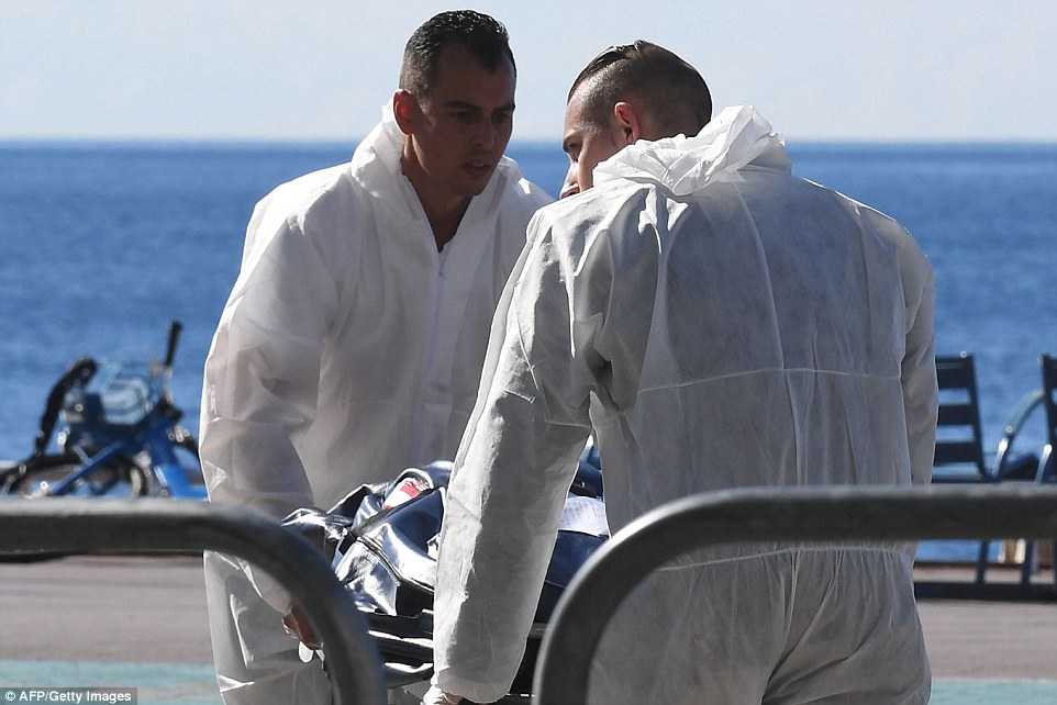 Forensics experts evacuate a dead body on the Promenade des Anglais seafront in the French Riviera town of Nice