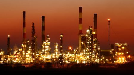 The chimneys of the Total Grandpuits oil refinery are seen just after sunset, southeast of Paris, France, March 1, 2021. REUTERS/Christian Hartmann