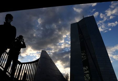 People are silhouetted in front of the head quarter of the European Central Bank (ECB,R) during sunset as the spread of the coronavirus disease (COVID-19) continues in Frankfurt, Germany, March 27, 2021. REUTERS/Kai Pfaffenbach