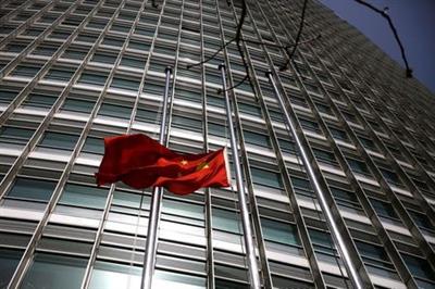 The Chinese national flag flies at half-mast outside a bank in Beijing, as China holds a national mourning for those who died of the coronavirus disease (COVID-19), on the Qingming tomb-sweeping festival, April 4, 2020. REUTERS/Tingshu Wang
