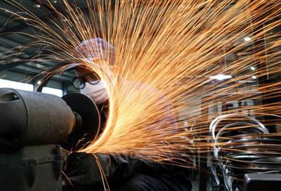 FILE PHOTO: A worker wearing a face mask works on a production line manufacturing bicycle steel rim at a factory in Hangzhou, Zhejiang province, China, March 2, 2020. China Daily via REUTERS