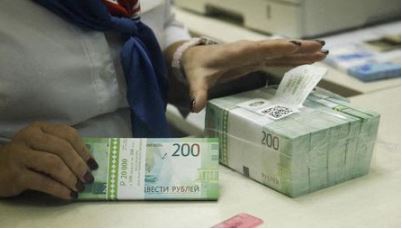 A cashier holds new 200 rouble banknotes in a bank in Moscow, Russia November 21, 2017. REUTERS/Maxim Shemetov