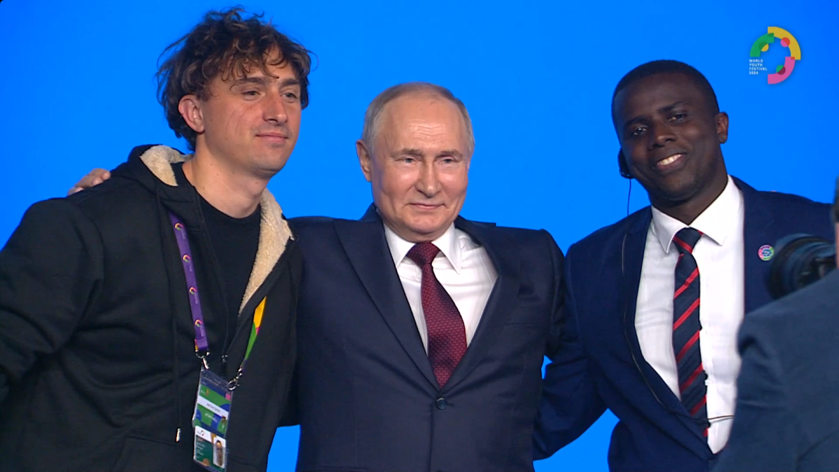 Парень из Италии слева попросил фото, чтобы развеять слухи о "ненастоящем Путине". Темнокожий парень справа попросил называться сыном российского президента! Его и поставим на царство в Африке! Шутка!