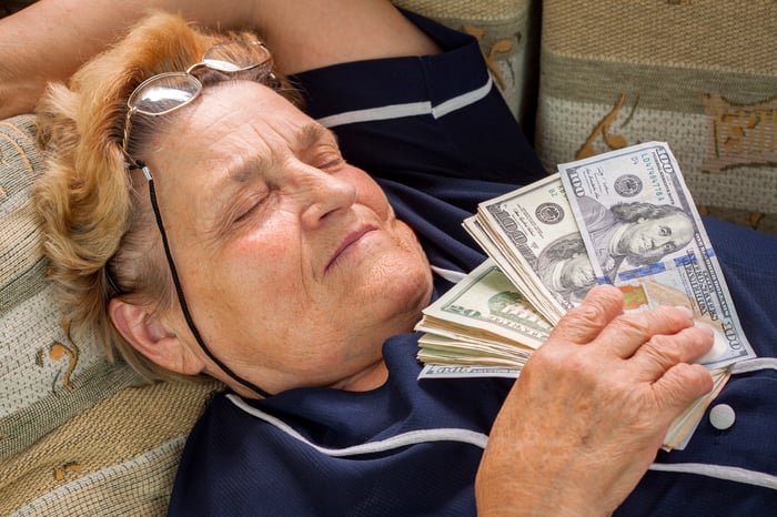 Sleeping person holding a wad of cash.