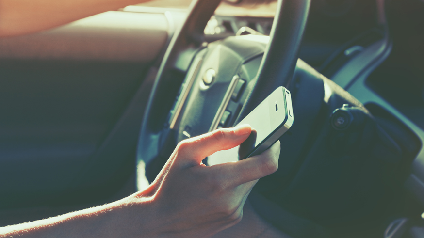 girls hand using smart phone while car driving