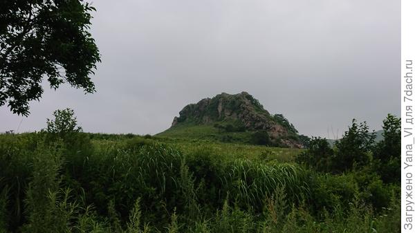 Впереди красивая одинокая скала, издалека напоминающая спящего дракона.