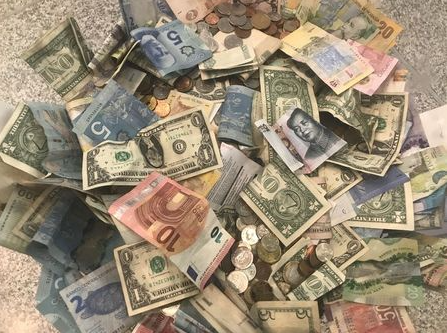 U.S. dollars and other world currencies lie in a charity receptacle at Pearson international airport in Toronto, Ontario, Canada June 13, 2018. REUTERS/Chris Helgren