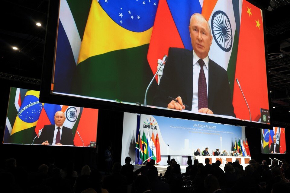    Президент РФ Владимир Путин (на экране) во время пресс-конференции в рамках саммита БРИКС. Фото: Сергей Бобылев/ТАСС