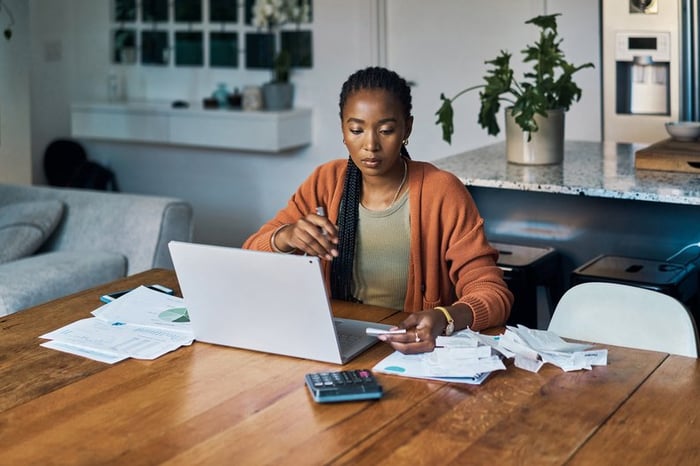 Person with laptop, bills, paperwork