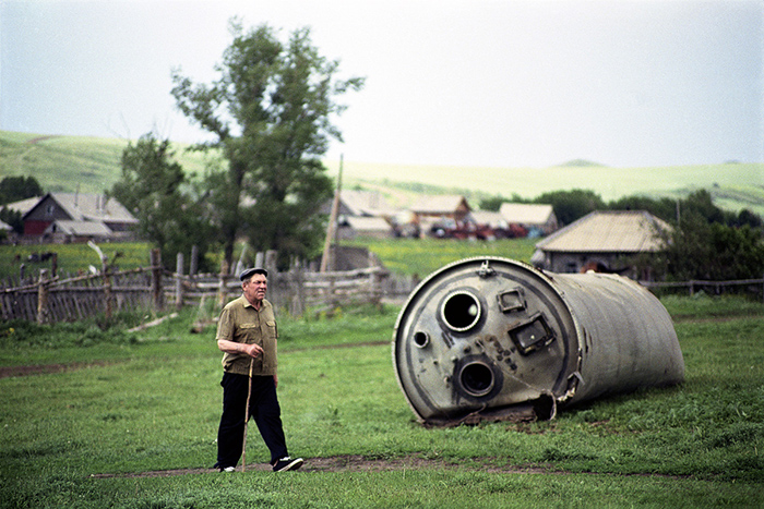 Местный житель идет мимо упавшей части ракеты. Фото: Jonas Bendiksen.