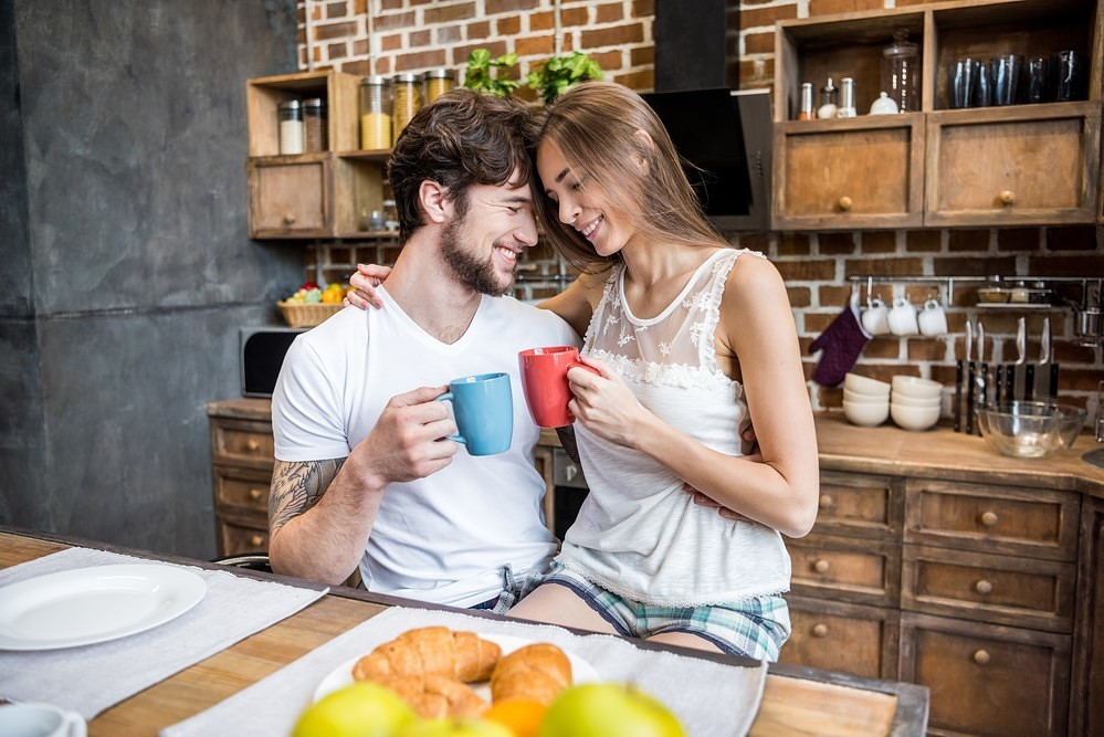 Муж и жена дома. Завтрак на кухне молодая пара. Пара завтракает на кухне. Вдвоем на кухне. Муж и жена на кухне пьют чай.